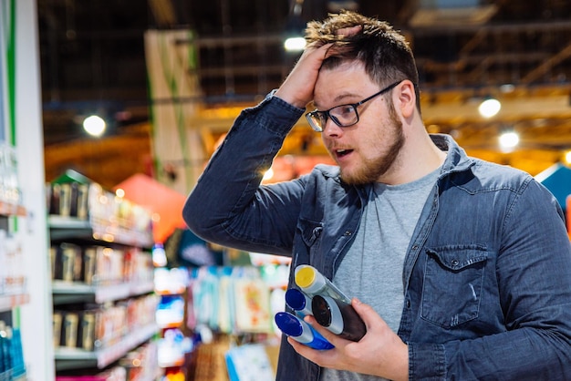 L'uomo non può decidere in negozio cosa comprare. concetto di acquisto. copia spazio