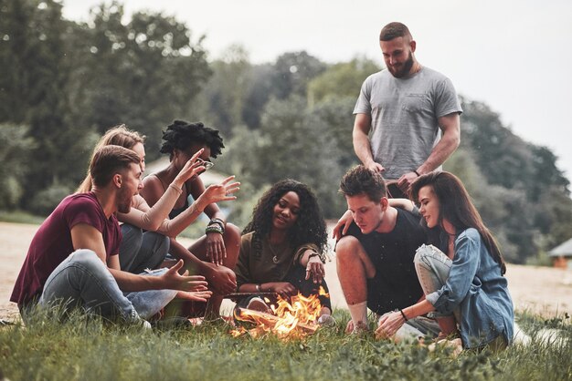 L'uomo parla con interesse. Un gruppo di persone fa un picnic sulla spiaggia. Gli amici si divertono durante il fine settimana.