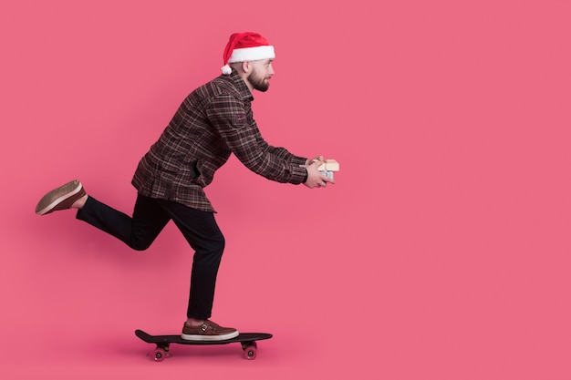 L'uomo pattinante con un cappello rosso e presente della santa sta pubblicizzando qualcosa su una parete dello studio