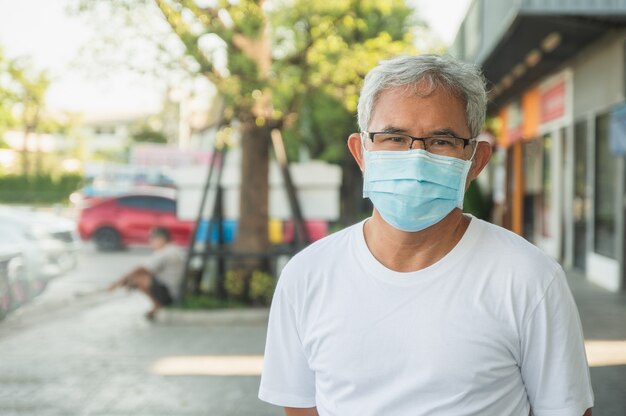 L'uomo più anziano indossa una maschera per proteggere il coronavirus covid19 nella città pubblica