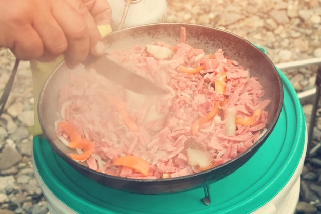 L'uomo prepara il cibo da campeggio Tonica