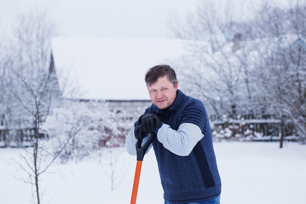 L'uomo pulisce la pala da neve