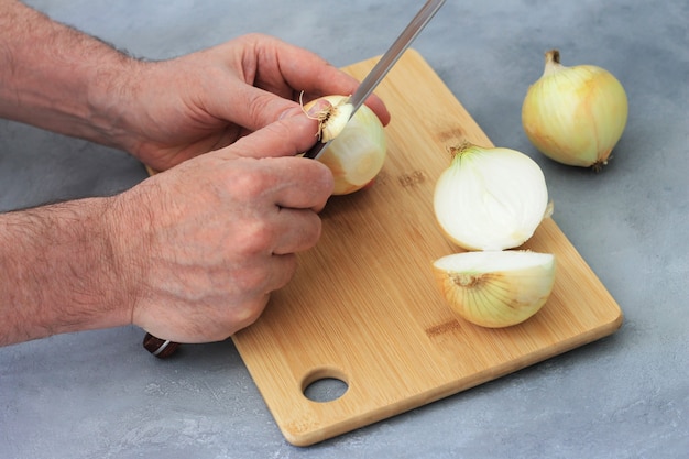 L&#39;uomo pulisce un coltello e taglia la cipolla