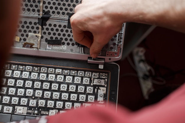 L'uomo ripara il laptop da solo la riparazione del computer