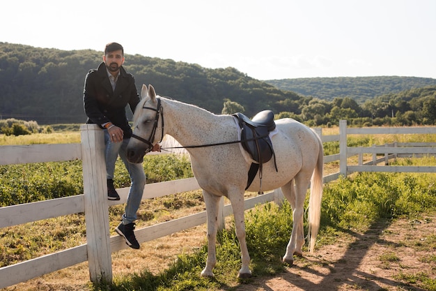 L'uomo riposa con un cavallo in un ranch