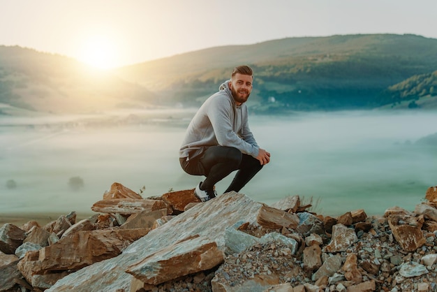 L'uomo riposa in cima al monte dopo l'allenamento mattutino