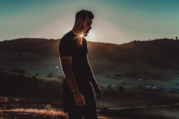 L'uomo riposa in cima alla montagna dopo l'allenamento.Concetto di motivazione