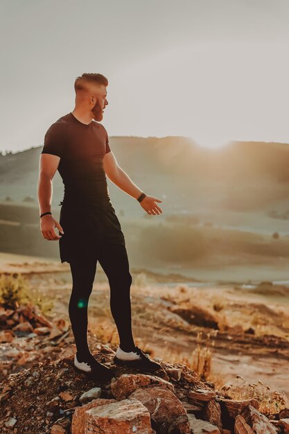 L'uomo riposa in cima alla montagna dopo l'allenamento.Concetto di motivazione