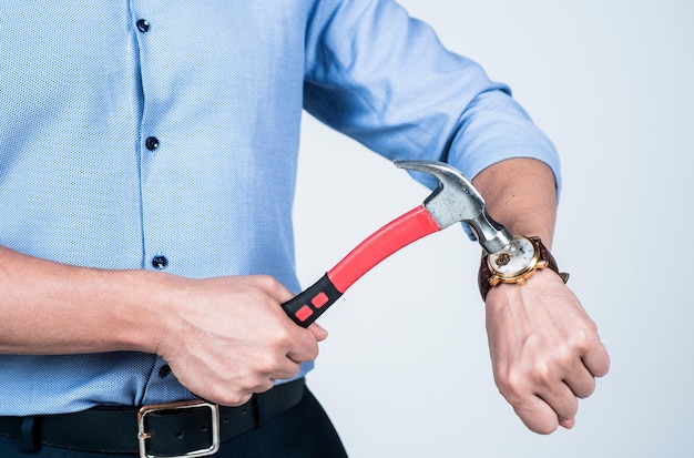 L'uomo ritagliata vista pausa orologio da polso dispositivo con strumento martello da carpentiere, uccidere il tempo.