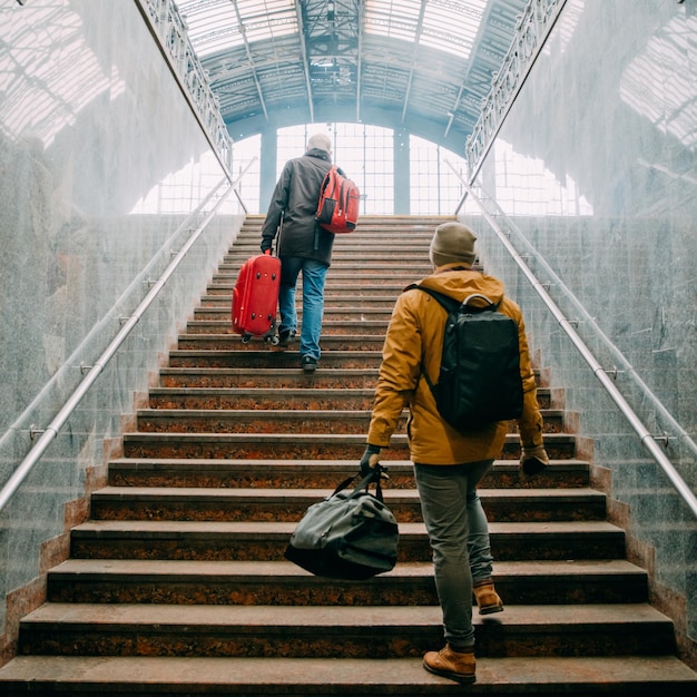 L'uomo sale le scale con le borse in mano alla stazione ferroviaria