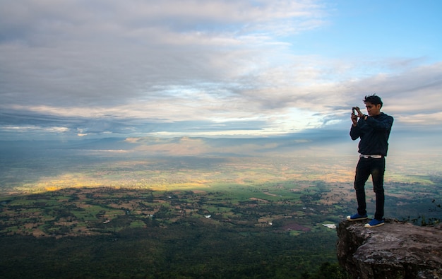 l&#39;uomo scatta foto sulla montagna scogliera