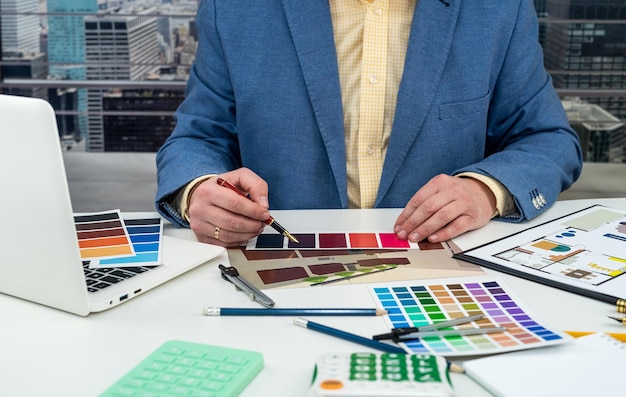 L'uomo sceglie i colori per il design delle camere disegnando appartamenti moderni con campioni di colore