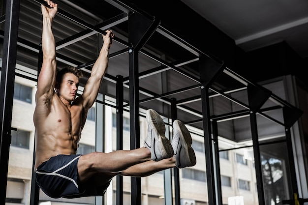 L&#39;uomo senza camicia che fa tira su in palestra