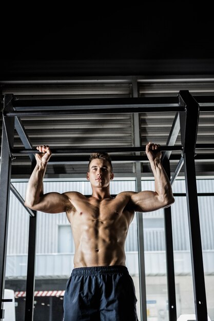 L&#39;uomo senza camicia che fa tira su in palestra