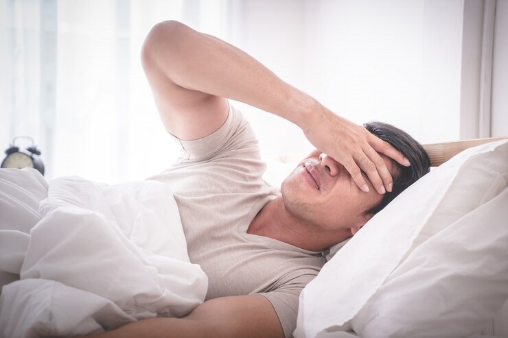 L'uomo senza sbornia insonne sul letto si svegliò con il mal di testa
