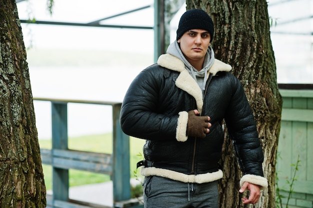 L'uomo serio arabo con giacca di pelle e cappello nero copia il suo idolo dal film d'azione.