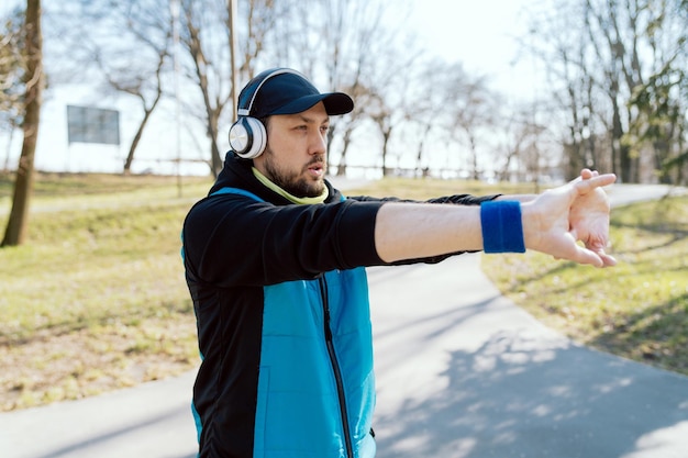 L'uomo si allena nel parco pubblico ascolta la corsa motivazionale