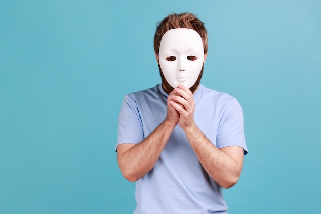 L'uomo si copre il viso con una maschera bianca nascondendo il falso anonimato della sua vera personalità misteriosa
