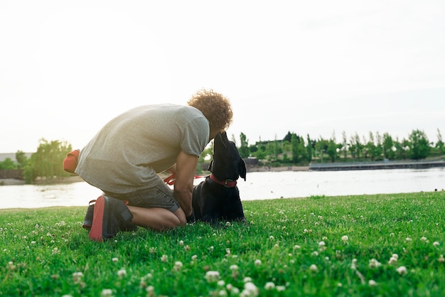 L'uomo si diverte e gioca con il suo cane nel parco.