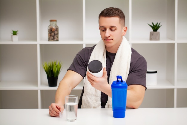 L'uomo si prepara un frullato di proteine nello shaker dopo l'allenamento