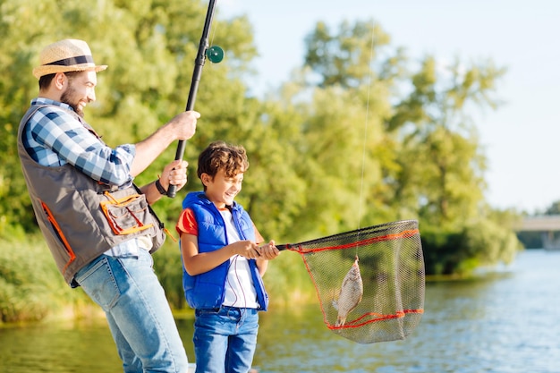 L'uomo si sente felice dopo aver catturato il pesce con suo figlio raggiante