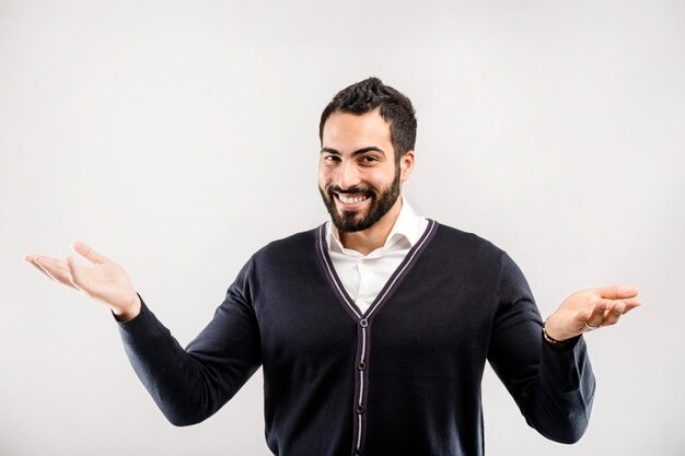 L'uomo sorridente barbuto tiene le mani alzate su sfondo bianco isolato