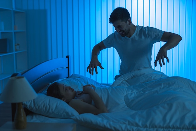 L'uomo spaventa una donna nel letto. notte