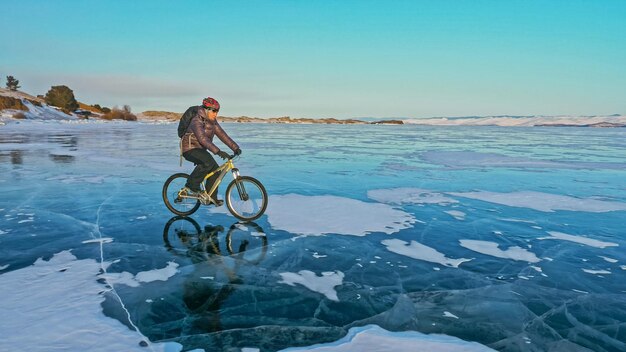 L'uomo sta andando in bicicletta sul ghiaccio Ghiaccio del lago ghiacciato Baikal Rid