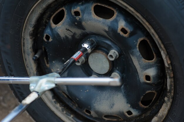 L'uomo sta cambiando la gomma con la ruota sull'auto