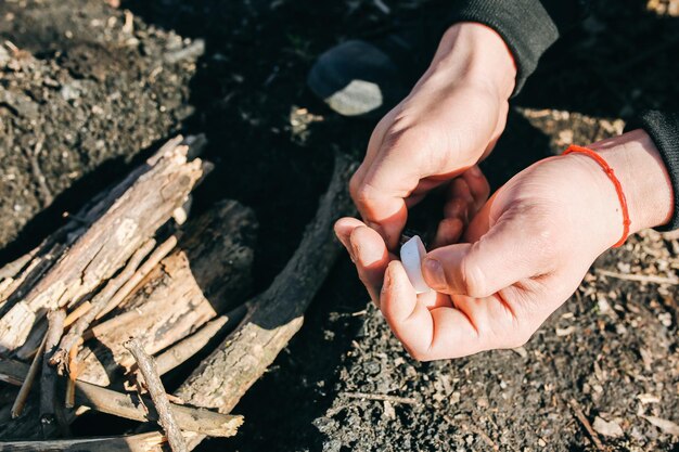 L'uomo sta facendo fuoco dall'alcool solido Turista nella natura all'aperto Legna da ardere per preparare il cibo