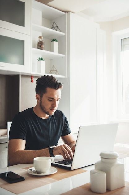 l'uomo sta lavorando a distanza da casa utilizzando un laptop