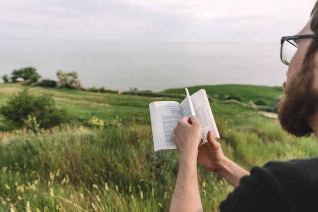 L'uomo sta leggendo un libro all'aperto