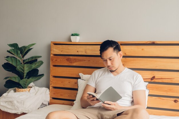 L'uomo sta leggendo un libro sul suo letto nel tardo pomeriggio.