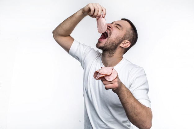 l'uomo sta mangiando pezzi di carne affettati