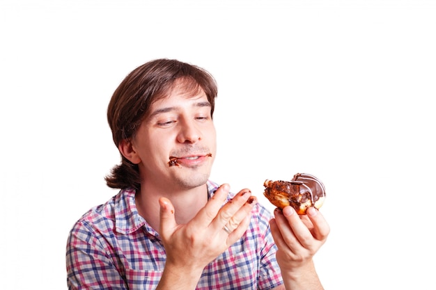 L'uomo sta mangiando una ciambella al cioccolato.