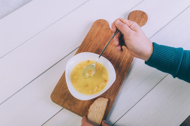 L'uomo sta mangiando una zuppa di brodo da una ciotola.