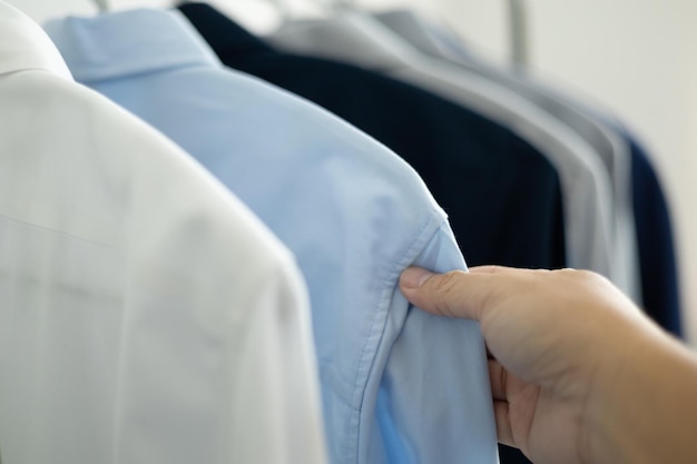 L'uomo sta scegliendo la camicia nella stanza dei vestiti a casa