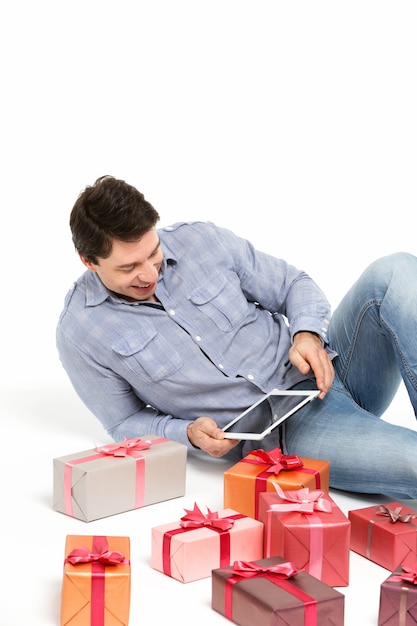 L'uomo sta sorridendo e sta esaminando la tavoletta elettronica