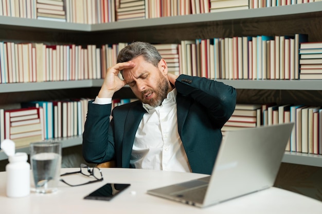 L'uomo stanco sente dolore tenendo gli occhiali sfregando gli occhi asciutti e irritati affaticati dal lavoro al computer stressato