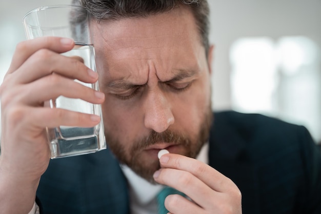 L'uomo stanco sente dolore tenendo gli occhiali sfregando gli occhi asciutti e irritati affaticati dal lavoro al computer stressato