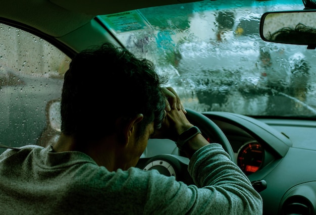 L'uomo stressato ha messo la faccia sul volante di un'auto mentre l'auto era ingorgata