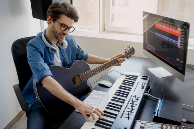 L'uomo suona la chitarra e produce colonne sonore elettroniche