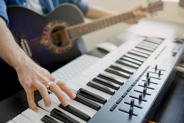 L'uomo suona la chitarra e produce colonne sonore elettroniche