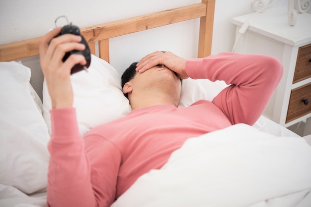 L&#39;uomo sveglia facendo spegnere la sveglia al mattino