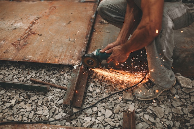 L'uomo taglia il ferro per strada.