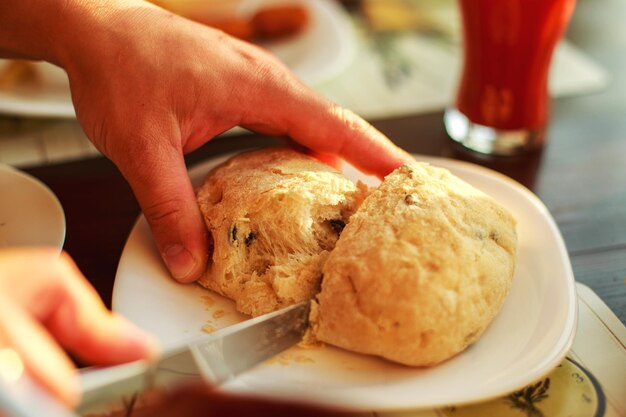 L'uomo taglia il pane fresco con un coltello