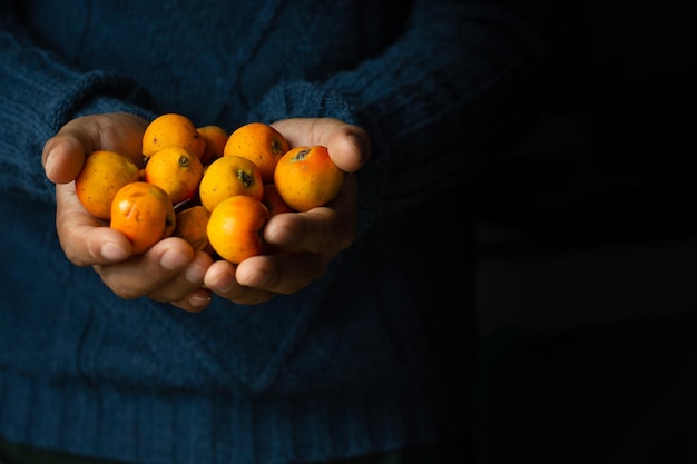 L'uomo tiene in mano deliziosi frutti di tejocote