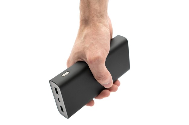 L'uomo tiene in mano il power bank per caricare i dispositivi mobili isolati su sfondo bianco