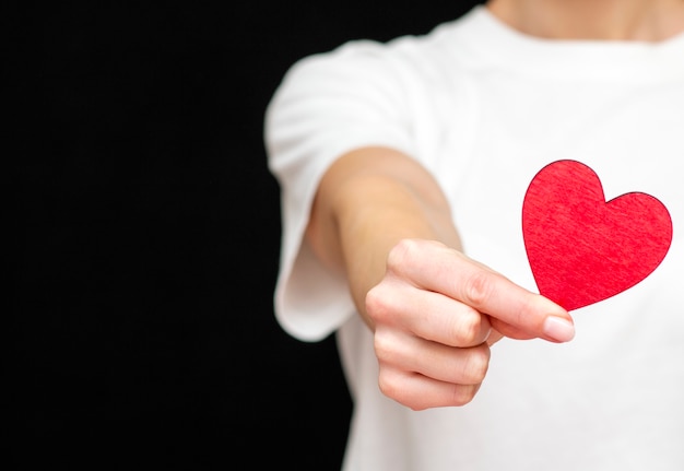 l'uomo tiene in mano un cuore rosso