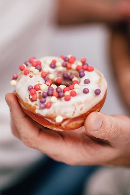 L'uomo tiene in mano una torta dolce con polvere rosa